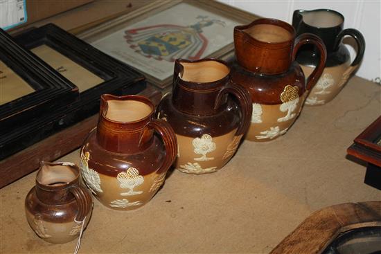 4 x Doulton stoneware hunting jugs and a Doulton Dewars Whisky jug(-)